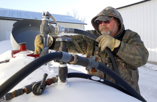 Arenson Oil and Propane delivery driver Don Bedford fills up an empty propane tank in Sandwich, Illinois January 29. Midwest propane inventories had rebounded somewhat but were still below the five-year average, a government report said Feb. 12. While propane prices have declined, consumers are still struggling to pay for their tank fills. Photo: Reuters/Jeff Haynes