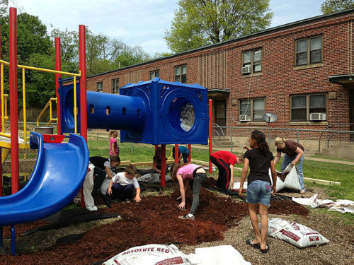 St. John’s House Learning and Development Center volunteers and participants work on the playground outside the center at Marcum Terrace apartments in Huntington, West Virginia. Photo: St. John’s House Learning and Development Center