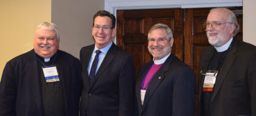 Episcopal Urban Caucus President the Rev. Robert Brooks, Connecticut Gov. Dannel Malloy, Connecticut Bishop Ian Douglas and the Rev. Peter Bushnell, who chairs the Connecticut diocese’s Social Justice and Advocacy Committee, gather during the caucus’ recent assembly in Meriden. Photo: John Armstrong