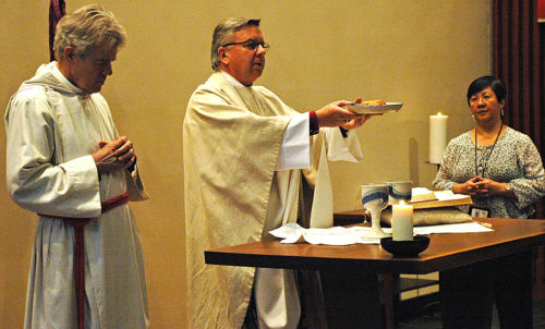 Archbishop David Moxon presides at Eucharist March 12 in the Episcopal Church Center’s Chapel of Christ the Lord. Moxon, the archbishop of Canterbury’s representative to the Holy See and director of the Anglican Centre in Rome, later hosted a forum on human trafficking and sexual violence. Assisting him at the Eucharist were the Rev. Canon James Calloway, Colleges and University of the Anglican Communion general secretary, and Angie Cabanban, the Domestic and Foreign Missionary Society’s diversity and ethnic ministries associate. Photo: Mary Frances Schjonberg/Episcopal News Service