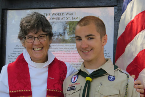 The Rev. C. Melissa Hall, interim rector at St. James Episcopal Church in Upper Montclair, New Jersey, and parishioner C. J. Kaloudis stand in front of the marker he created as an Eagle Scout project to highlight the church’s bell tower’s history as a memorial to World War I soldiers. Photo: Sharon Sheridan