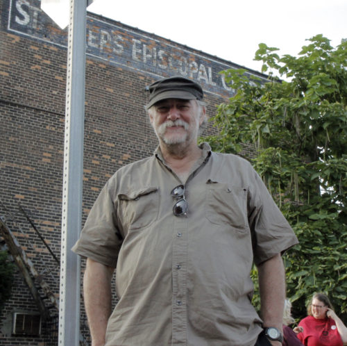 The Rev. Bill Wylie-Kellermann, a longtime social activist, stands outside St. Peter’s Episcopal Church on Monday, Sept. 7, watching the Labor Day Parade pass by. Photo: Lynette Wilson/ENS 