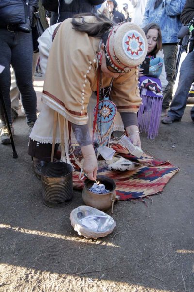 An elder woman sets fire to the Doctrine of Discovery. Photo: Lynette Wilson/Episcopal News Service 