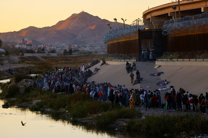 Migrantes no muro da fronteira em El Paso
